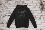 Sudadera negra infantil-juvenil con capucha ZASCA ZASCASTEIN con diseño original sobre fondo de pared
